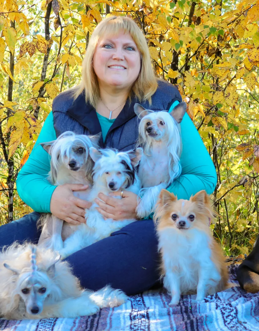 Laura Pabst, posing with five small dogs